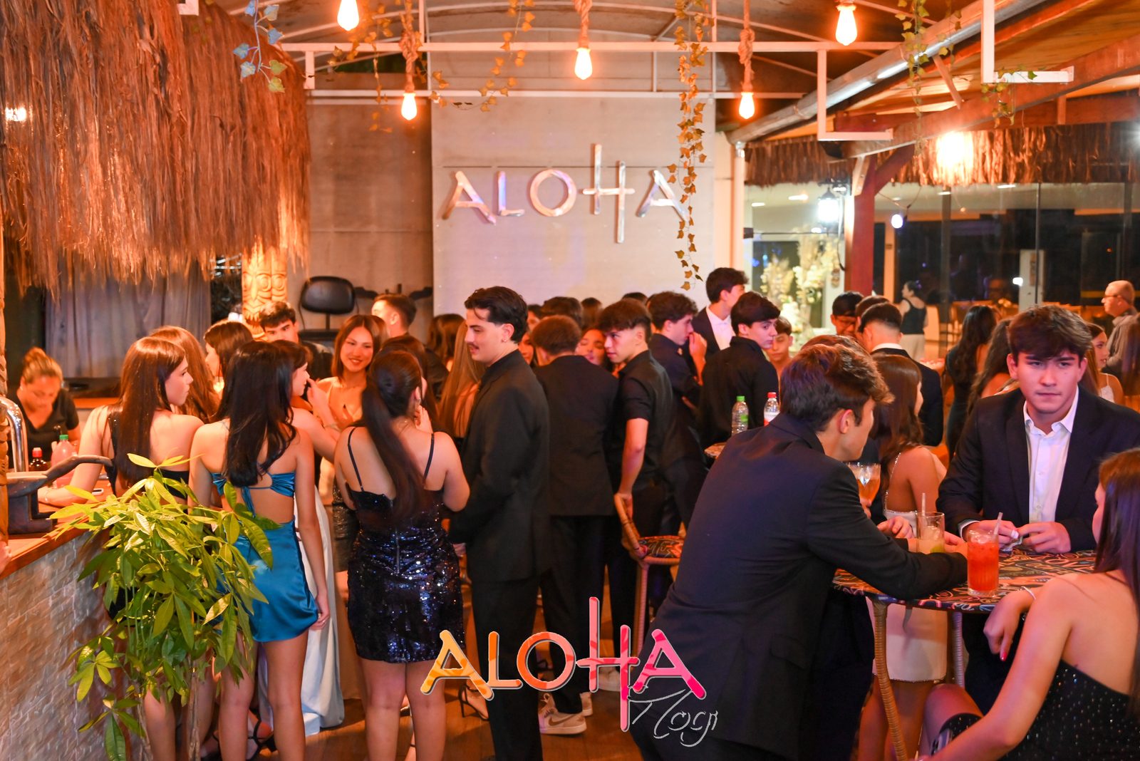 Formatura com convidados em frente ao letreiro Aloha