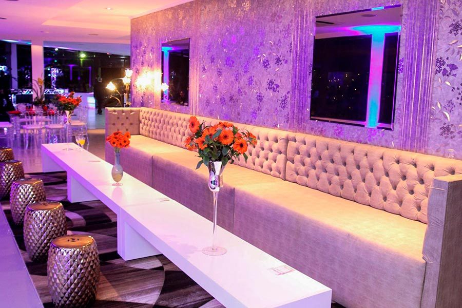 Lounge com sofá e iluminação lilás