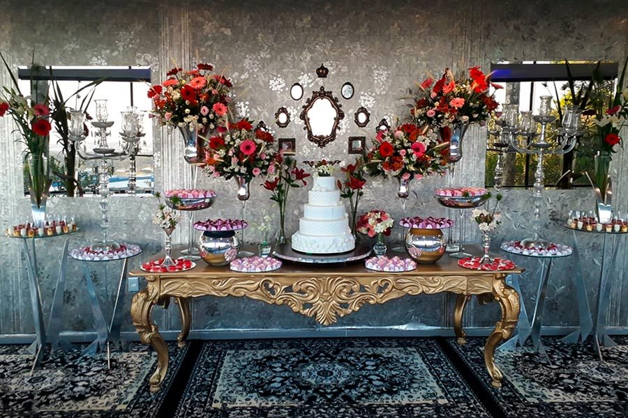 Mesa de bolo com espelho e flores vermelhas