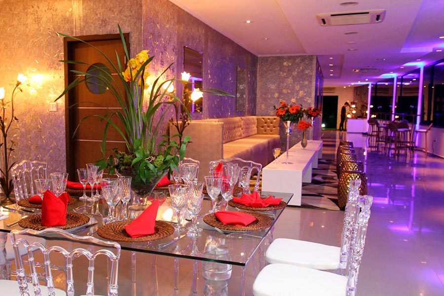 Mesa com flores vermelhas no salão